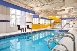 a swimming pool with a slide in a building at TownePlace Suites by Marriott Fort McMurray in Fort McMurray