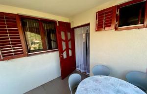 a room with a table and chairs and a red door at Apartment Beach View in Kruševo