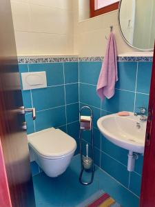 a blue bathroom with a toilet and a sink at Apartment Beach View in Kruševo