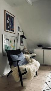 un soggiorno con sedia e tappeto di pelo di ApartmentInCopenhagen Apartment 1597 a Copenaghen