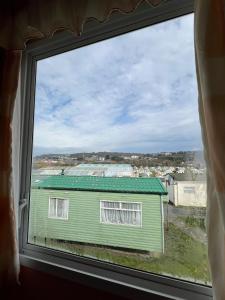 a view of a green house from a window at Light and Airy 2 Bedroom Mobile Home in Aberystwyth