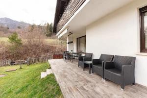 un patio avec des chaises noires et une table sur une terrasse dans l'établissement Holiday Home Bela, à Bohinjska Bela