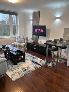 a living room with a netflix sign on the wall at Priory park view in Southend-on-Sea
