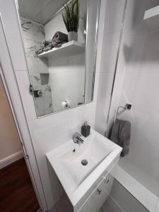 a white bathroom with a sink and a mirror at Priory park view in Southend-on-Sea