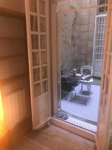 an open door to a patio with a table at Au coeur de Bordeaux in Bordeaux