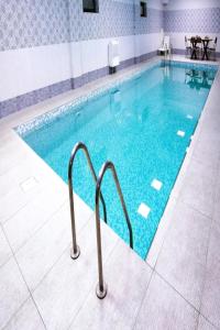 uma piscina com água azul num edifício em Altus Hotel em Baku