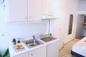 a kitchen with white cabinets and a sink at Whitelist Apartment NEW in Mykonos Town in Mikonos