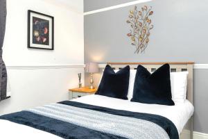 a bedroom with a large bed with blue pillows at NEW Oakhill House by Truestays - 5 Bedroom House in Stoke-on-Trent in Trent Vale