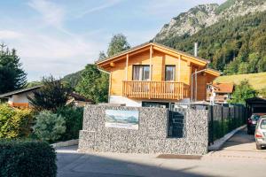 a house with a stone wall in front of it at Haus Plattenbichlstraße - Ferienhäuser Alpenglück in Oberstdorf