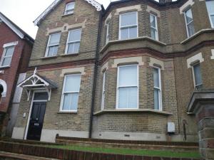 a brick house with white windows and a black door at Epsom Road studio flat in Croydon