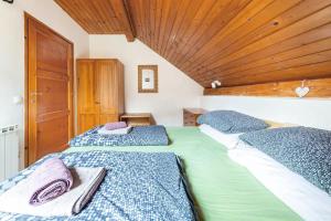 2 camas individuais num quarto com tecto em madeira em Holiday Home Bela em Bohinjska Bela