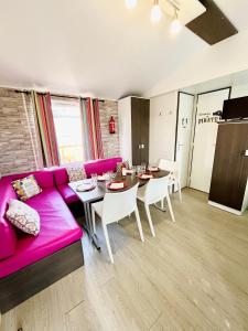 een woonkamer met een roze bank en een tafel bij mobil home "AMBRE" 6p, CLIM&TV in Vic-la-Gardiole