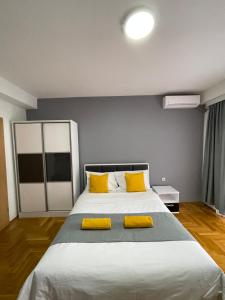 a bedroom with a large bed with yellow pillows at Front Beach Exclusive Apartments in Struga