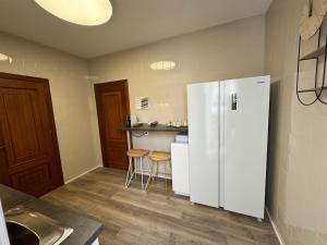 a kitchen with a white refrigerator and two stools at ENTOELCENTRO in Baeza