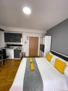 a bedroom with a large bed with yellow pillows at Front Beach Exclusive Apartments in Struga