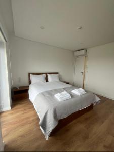 a bedroom with a large bed with two pillows at O Pôr do Sol do Gerês in Paradela
