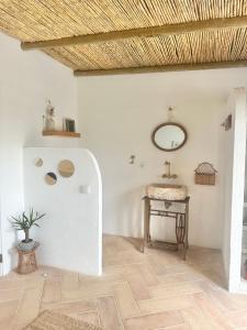 Zimmer mit einem Tisch und einem Spiegel an der Wand in der Unterkunft La Quinta da Liberdade - Ferme de charme en Algarve in Pechão