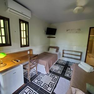 a room with a bed and a desk and a table at Casa Araribá - Ilha Grande in Abraão