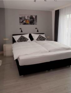 een slaapkamer met een groot bed met witte lakens bij Schelvis Apartments in Zandvoort
