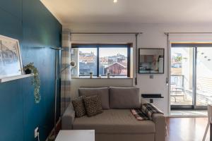 - un salon avec un canapé et une fenêtre dans l'établissement Top floor apartment with Sunny Balconies, à Porto