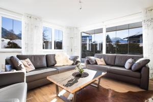 a living room with a couch and a table at Haus Alpgaustraße - Ferienhäuser Alpenglück in Oberstdorf