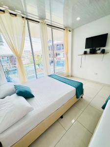 a bedroom with a large bed and a large window at TORRES DEL MESÓN LUXURY APARTA HOTEL Doradal in Doradal