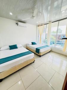 a bedroom with two beds and a large window at TORRES DEL MESÓN LUXURY APARTMENTS Doradal in Doradal