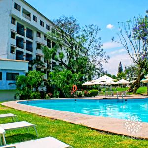 a swimming pool in front of a building at Hotel Coral Cuernavaca Resort & Spa in Temixco