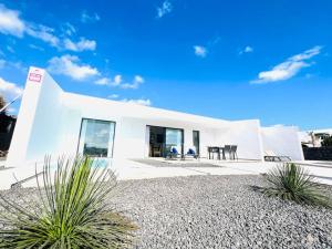 una casa blanca con algunas plantas delante de ella en Pasito Luxury Villa, en Charco del Palo