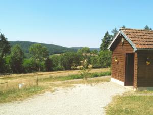 a small building with a door on the side of a field at Yourte et nature in Magnien