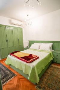 a bedroom with green cabinets and a bed with a red blanket at Amazing Flat 9 mins to Airport at Heliopolis in Cairo