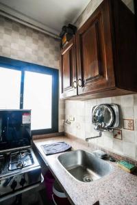 a kitchen with a sink and a stove at Amazing Flat 9 mins to Airport at Heliopolis in Cairo