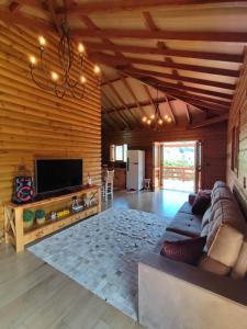 ein Wohnzimmer mit Couch und Flachbildfernseher in der Unterkunft Cabana Bela Vista in Santa Maria do Erval