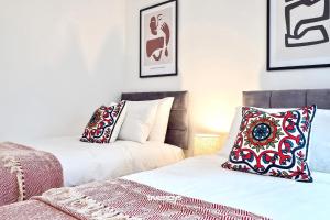 1 dormitorio con 2 camas con almohadas y cuadros en la pared en Fielding House by Truestays - NEW 3 Bedroom House in Stoke-on-Trent, en Stoke on Trent