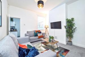 ein Wohnzimmer mit einem Sofa und einem TV in der Unterkunft Fielding House by Truestays - NEW 3 Bedroom House in Stoke-on-Trent in Stoke on Trent