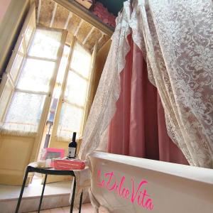 パレルモにあるVittorio Emanuele Rooms di Prinziのバスルーム(テーブル、窓、バスタブ付)