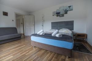 1 dormitorio con cama y sofá en Nad Cedronem, en Wambierzyce