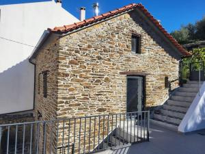 a stone house with a staircase in front of it at Da Silva house in Seia