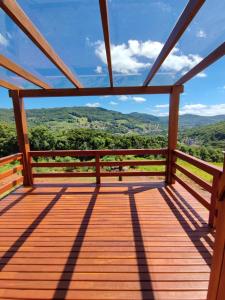 una terraza de madera con vistas a las montañas en Cabana Bela Vista en Santa Maria do Erval