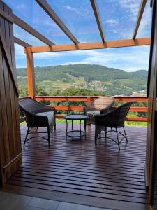 4 sillas y una mesa en una terraza con vistas en Cabana Bela Vista en Santa Maria do Erval