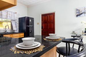 a kitchen with a counter with plates and bowls on it at Cozy, upscale apartment centrally located in Kgn 6 in Kingston