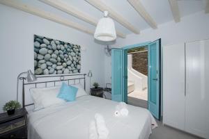 une chambre avec un lit blanc et une porte bleue dans l'établissement Villa Danelina by Whitelist Mykonos, à Ornos 40 autres photos