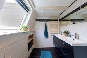 a bathroom with a sink and a window at Posthuisje Zandvoort in Zandvoort