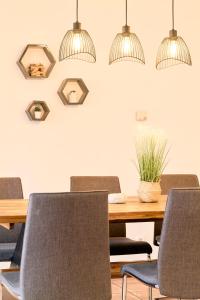 a dining room table with chairs and pendant lights at Stilvolle Gartenterrassenwohnung mitten in Bregenz in Bregenz