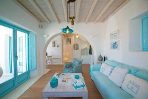 un salon avec un canapé bleu et une table dans l'établissement Villa Danelina by Whitelist Mykonos, à Ornos