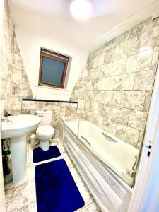 a bathroom with a tub and a toilet and a sink at Cozy One Bedroom Apartment With Free Car Park In London in London