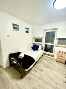 a bedroom with a bed and a large window at Cozy One Bedroom Apartment With Free Car Park In London in London