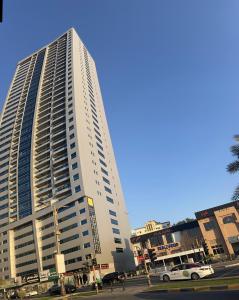 a tall white building with cars parked in front of it at F30,R4,Single Room on the beach attach bath in Ajman 