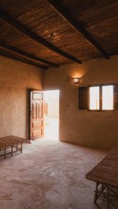 an empty room with two benches and a door at Stamps Siwa Oasis in Siwa
