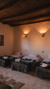 three beds in a room with lights on the wall at Stamps Siwa Oasis in Siwa